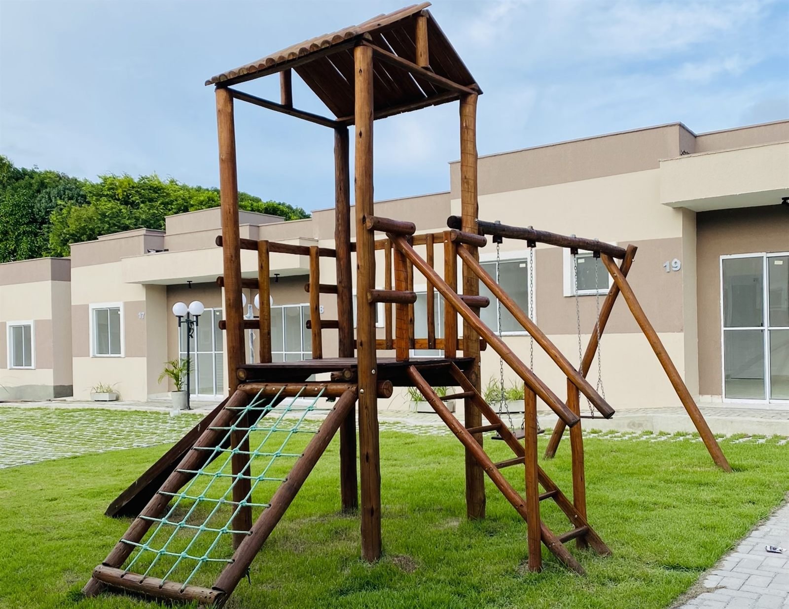 Playground de eucalipto tratado com escorregador, balanço e rede de escalada